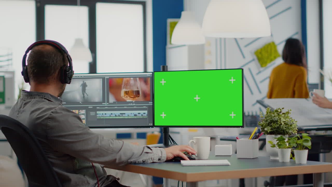 Videografo che utilizza un computer con display chroma key