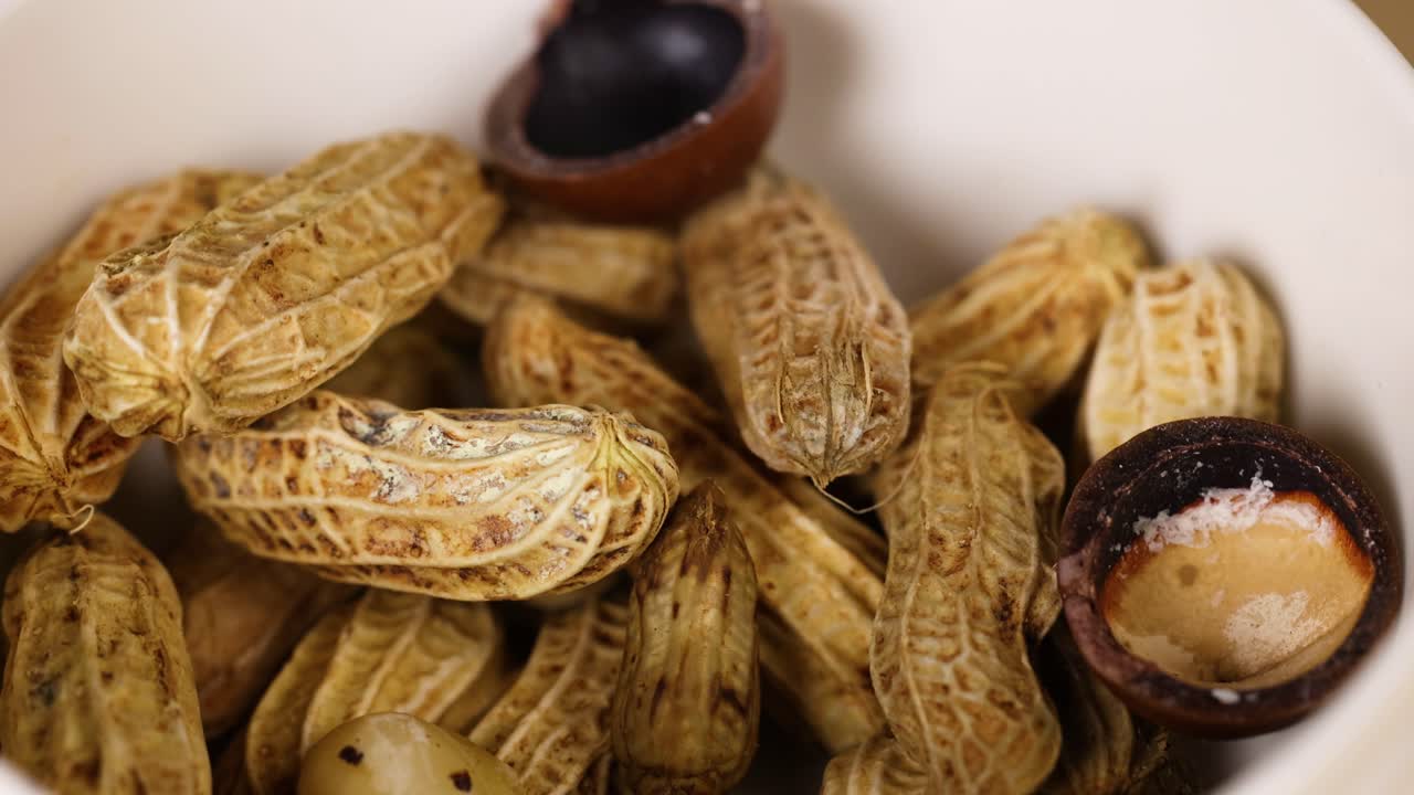 Peanuts and chestnuts arranged in a white bowl