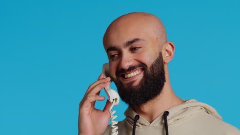 middle eastern man talking to people on landline phone call