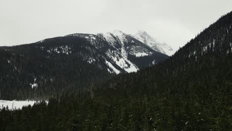 Establishing-aerial-drone-shot-of-trees-and-mountain-landscape-at-Duffey-Lake-in-British-Columbia,-Canada