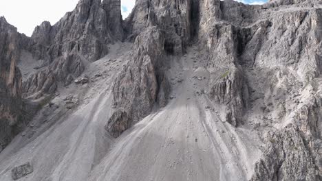 Impresionante-Vista-De-Los-Dolomitas-En-El-Parque-Natural-Puez-Geisler-En-Tirol-Del-Sur,-Que-Muestra-Las-Características-Formaciones-Escarpadas-De-Piedra-Caliza,-Pendientes-De-Grava-Suelta-Y-Zonas-Verdes.