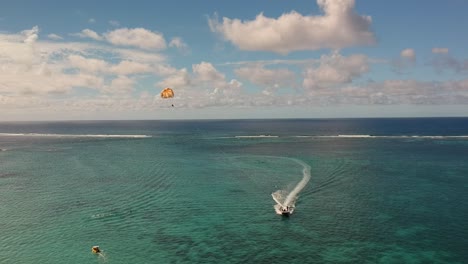 Toma-Aérea-De-Una-Lancha-Deportiva-Tirando-De-Un-Paracaídas-Para-Hacer-Parasail