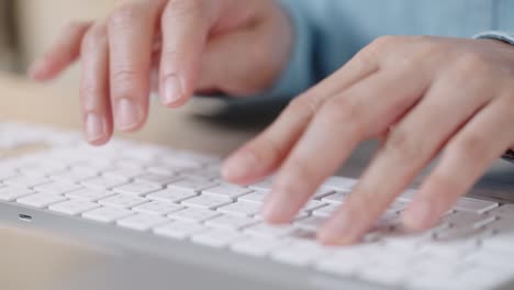 mano de cerca de una mujer de negocios escribiendo teclado computadora de escritorio en la oficina de escritorio