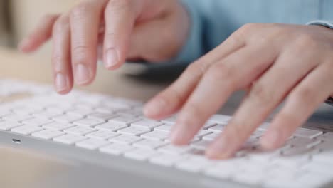 close up hand of a business woman typing keyboard desktop computer on desk office