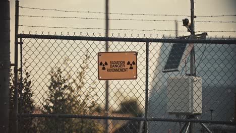 Radiation-Danger-Sign-on-Barbed-Wire-Fence-with-Radioactive-Particles-in-Slow-Motion-4K