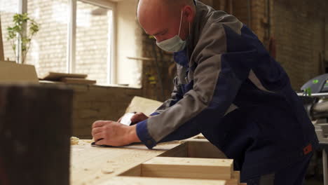 carpenter using a planer in a workshop