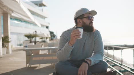 man enjoying coffee by the sea