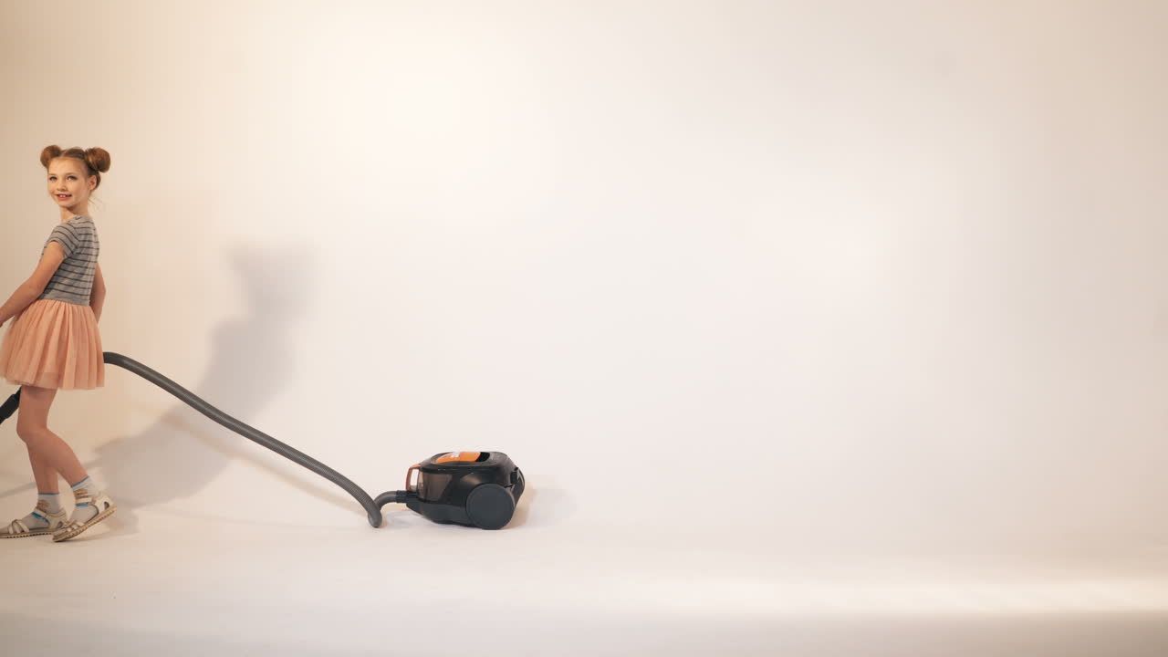 Little children play with a vacuum cleaner. Emotions of the child. Studio shooting of children.