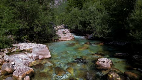 agua de río limpia que fluye sobre piedras de colores en el parque del valle de valbona en albania