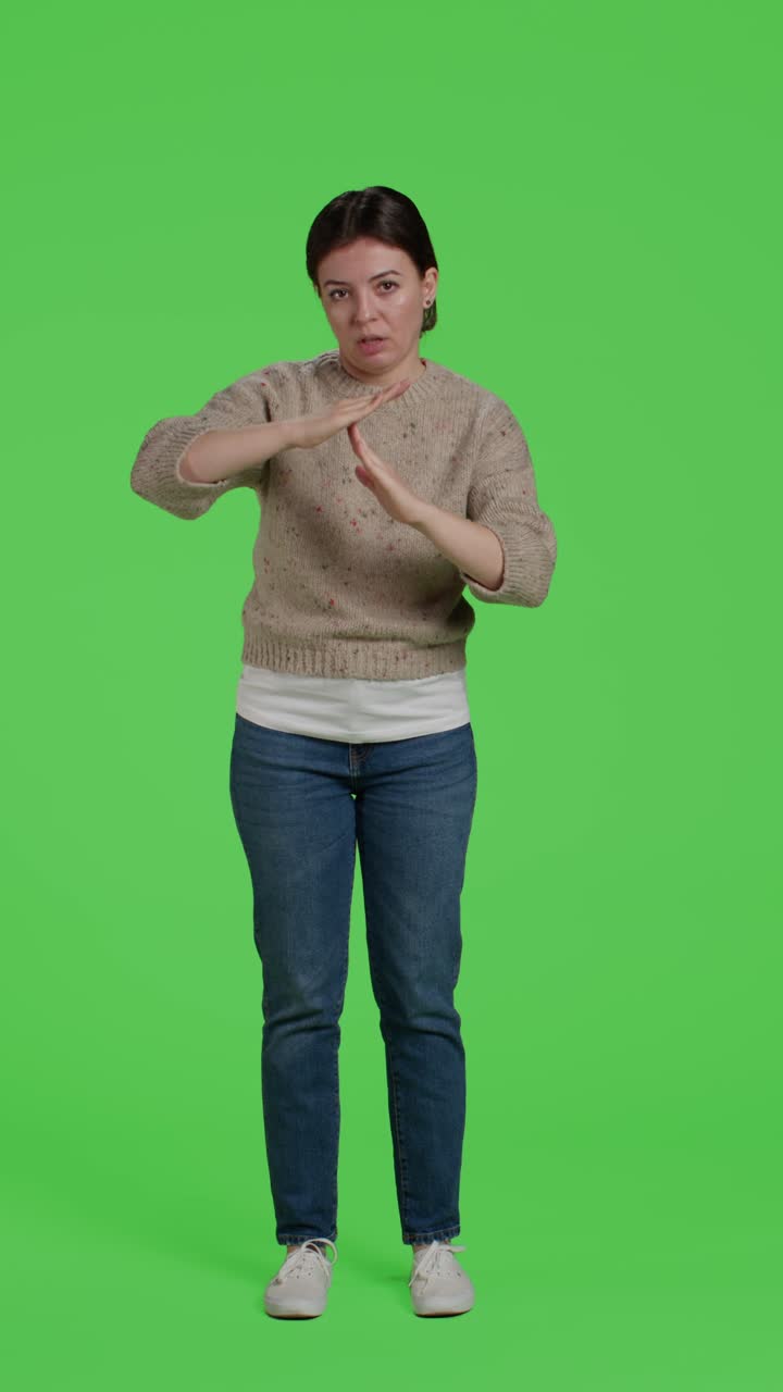 Vertical video: Front view of full body girl doing t shape timeout sign