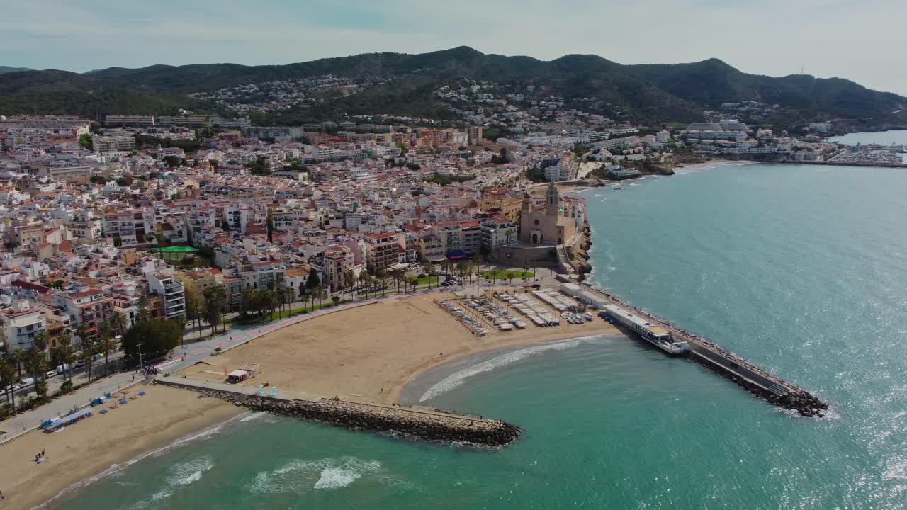ciudad de sitges y costa en españa con montañas en el fondo, vista aérea
