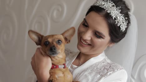 Beautiful-and-lovely-bride-in-night-gown-and-veil-with-funny-dog.-Wedding