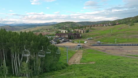 aerial pullback above ski chair lift on grassy green slopes in the summer, colroado