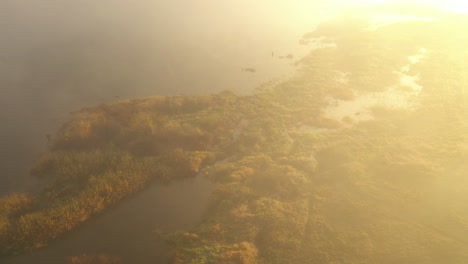 Drone-aerial-view-of-fog-over-the-Nemunas-river-during-sunrise-in-early-autumn-morning-in-Kaunas-county,-Lithuania