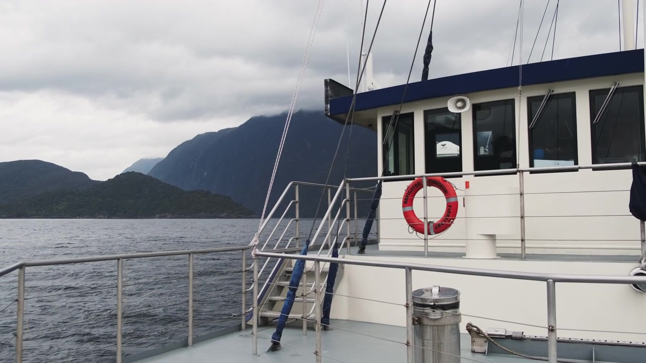 Malerische Fjordkreuzfahrt, Schaukelbewegung des Bootes in den Wellen, mit majestätischen Bergen als atemberaubender Kulisse.