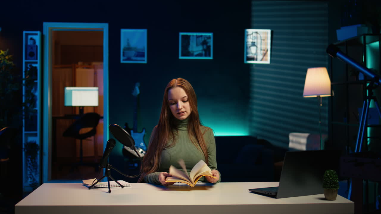 Young girl films video review of book, browsing through pages