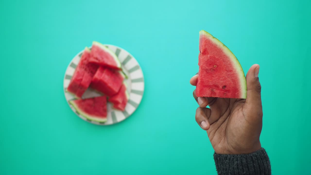 Watermelon slices on a plate and in hand