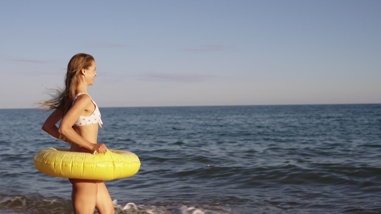 Woman Running on Beach with Life Preserver