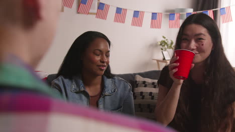 Friends-At-Home-Celebrating-With-Party-For-American-Independence-Day-4th-July-Talking-And-Drinking