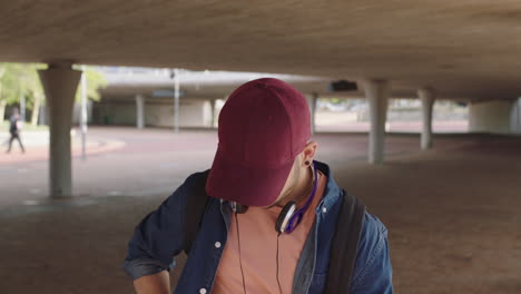 attractive young hispanic man portrait of student listening to music on headphones