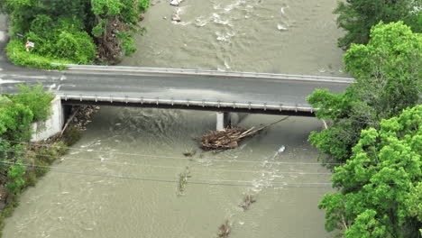 Telephoto-Aerial-View:-Bridge-with-Trees-Pinned-to-Trusses,-Vermont-Flooding-2023