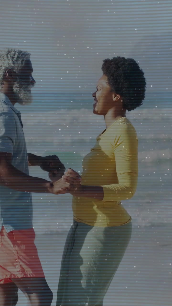Vertical video: Couple swaying on beach handhold sparking dance for ads scanlines passing over them