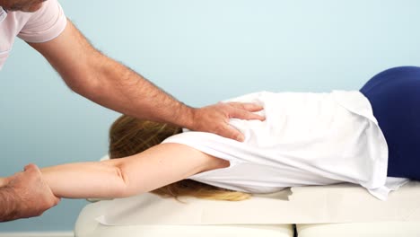 mujer rubia en una sesión de fisioterapia para ayudar a aliviar el dolor en el brazo