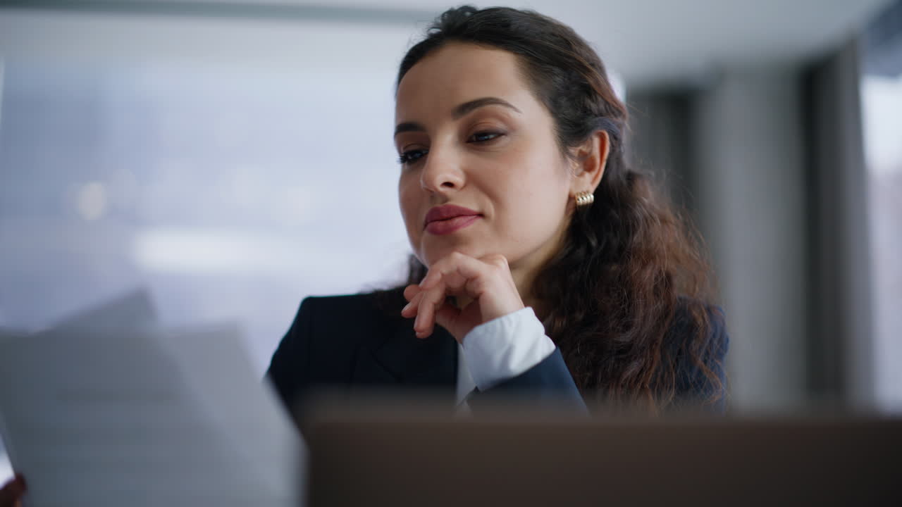 Portrait woman watching documents at corporate office. Lady examining papers