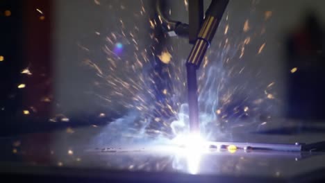 close-up shot of dynamic welding process showing sparks and bright light emitting from the electrode during metal fabrication