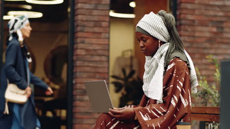 islamic woman using computer outdoors