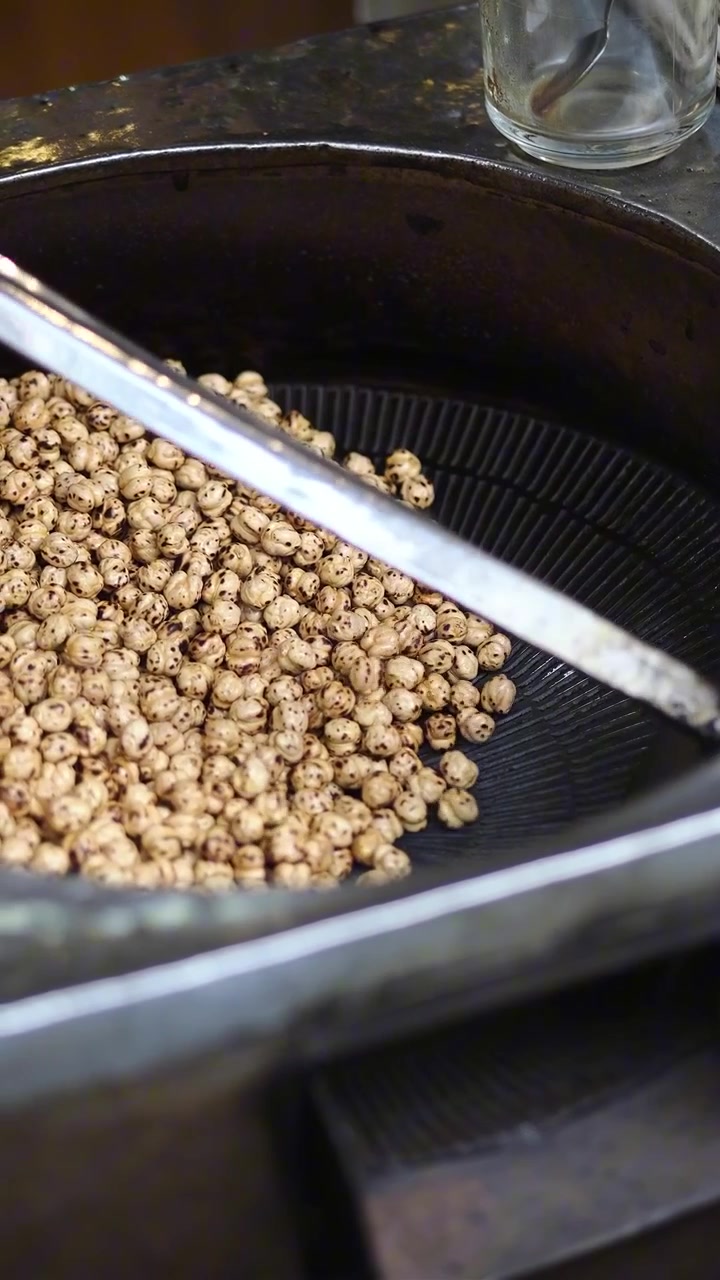 Roasted Chickpeas Being Stirred in a Large Metal Pan