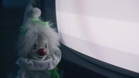 antique clown facing an old television
