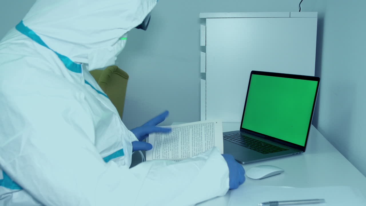 médico en ppe escribiendo notas sobre investigación médica durante una pandemia - tiro medio