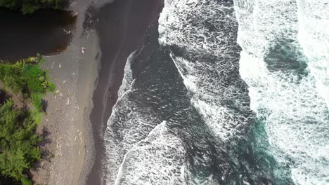 waves wash ashore black sands beach at punalu'u on hawaii's big island - straight down aerial bird's eye view