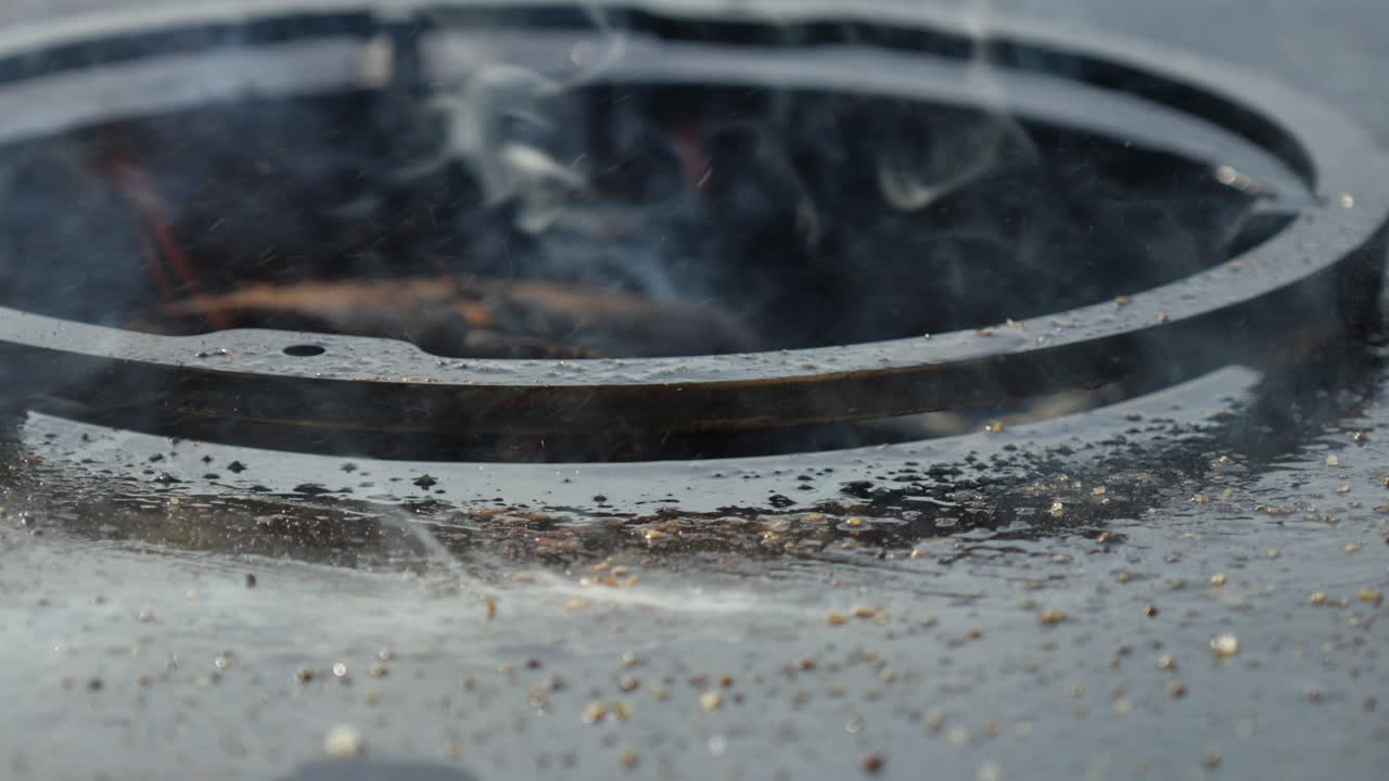Slowmotion shot of a steak being removed from a bbq and creating a flame