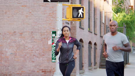 Young-black-couple-jogging-in-Brooklyn-street,-close-up