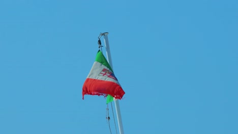 bandera italiana ondeando contra el cielo azul claro