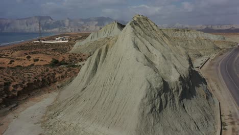 Luftaufnahme-Des-Verwitterten,-Erodierten-Hügels-Neben-Einer-Leeren-Straße-In-Der-Nähe-Der-Küste-Von-Balochistan