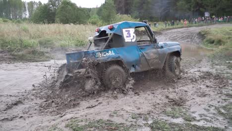 blue truck driving through deep mud