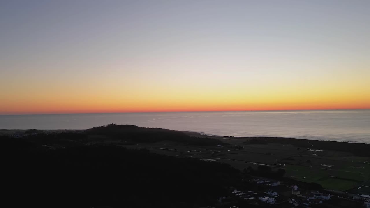 Přiblížený záběr úchvatného západu slunce nad oceánem, zvýrazňující zářivé odrazy na vodě a syté zlatavé tóny na obzoru.