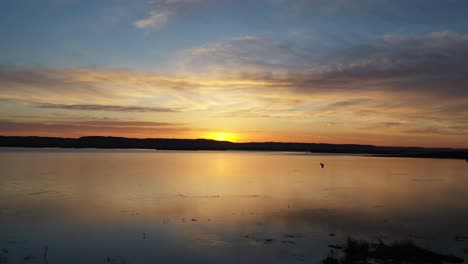 amanecer o atardecer sobre un cuerpo de agua tranquilo