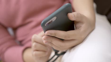 Close-up-focus-on-woman-hands-using-a-smartphone-to-social-media