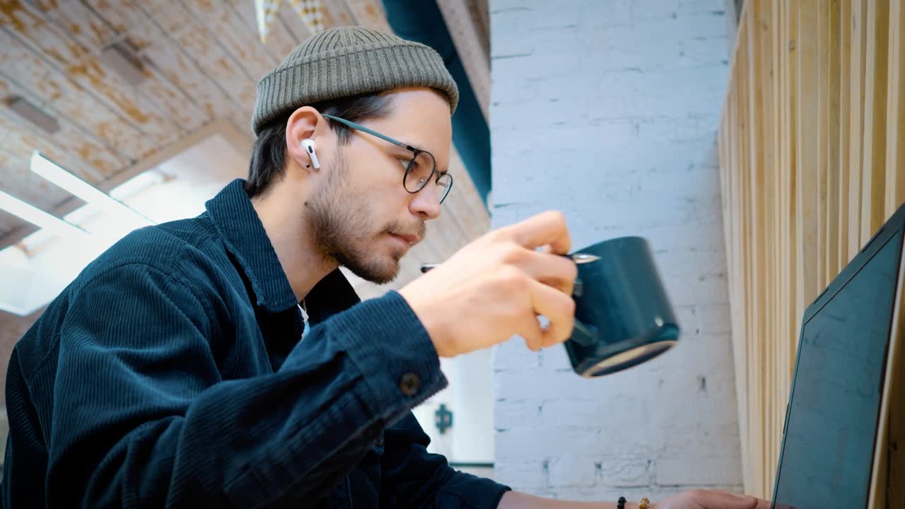 un hombre con gafas en la oficina bebe té o café. teletrabajo
