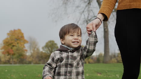 mom and son are walking in the autumn park