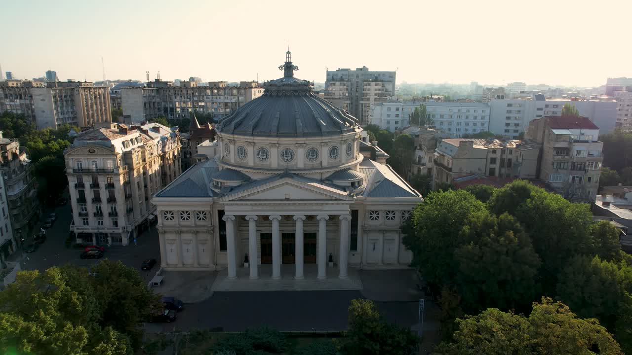 un impresionante amanecer sobre el ateneo rumano en bucarest, con un impresionante paisaje urbano en el fondo, vista de avión no tripulado