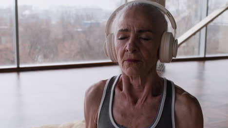 senior woman meditating with headphones