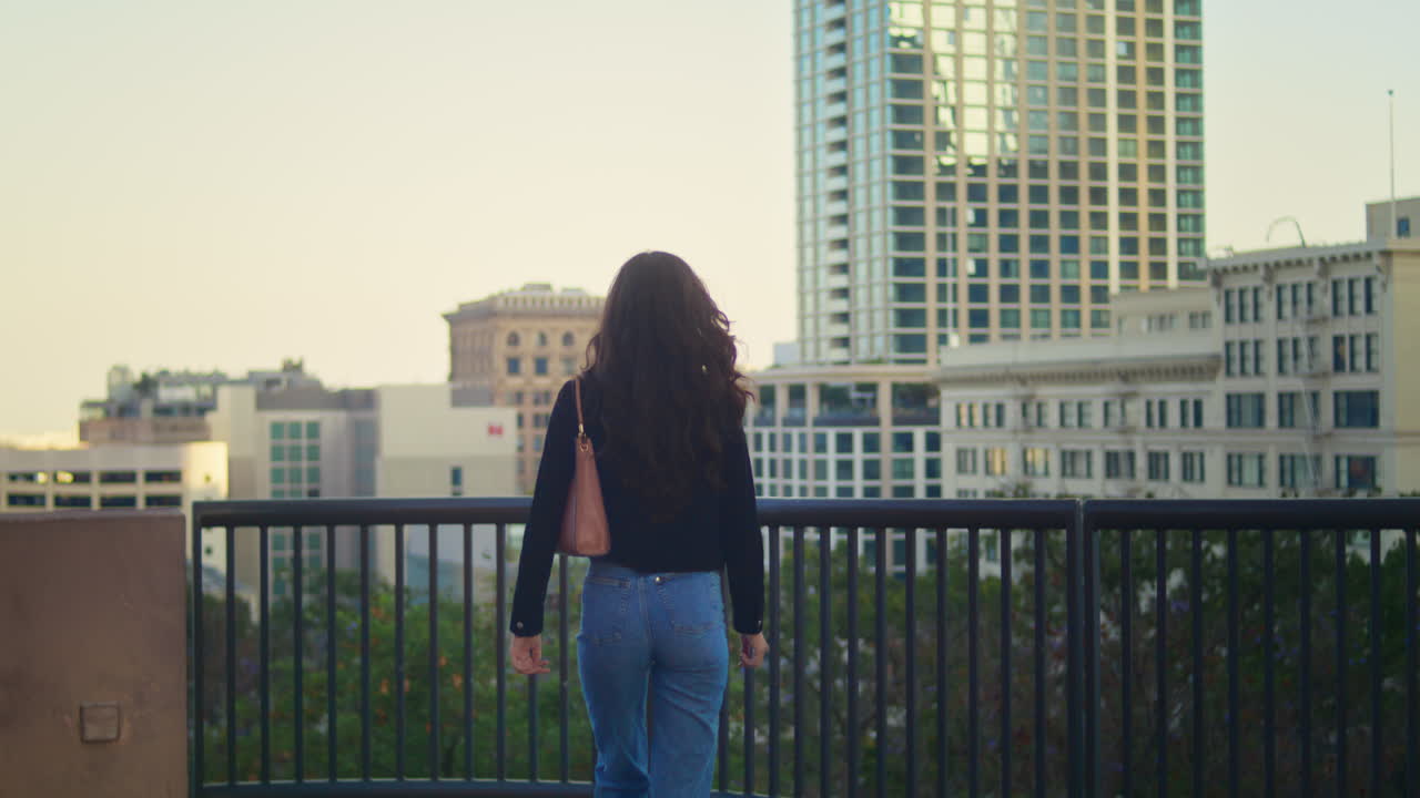 una joven desconocida caminando por la plataforma de observación. un turista con estilo mirando la ciudad.