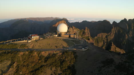 drone aerial footage flying over pico do arieiro, and the radar station on the peaks at sunrise with surrunding mountains of maderia