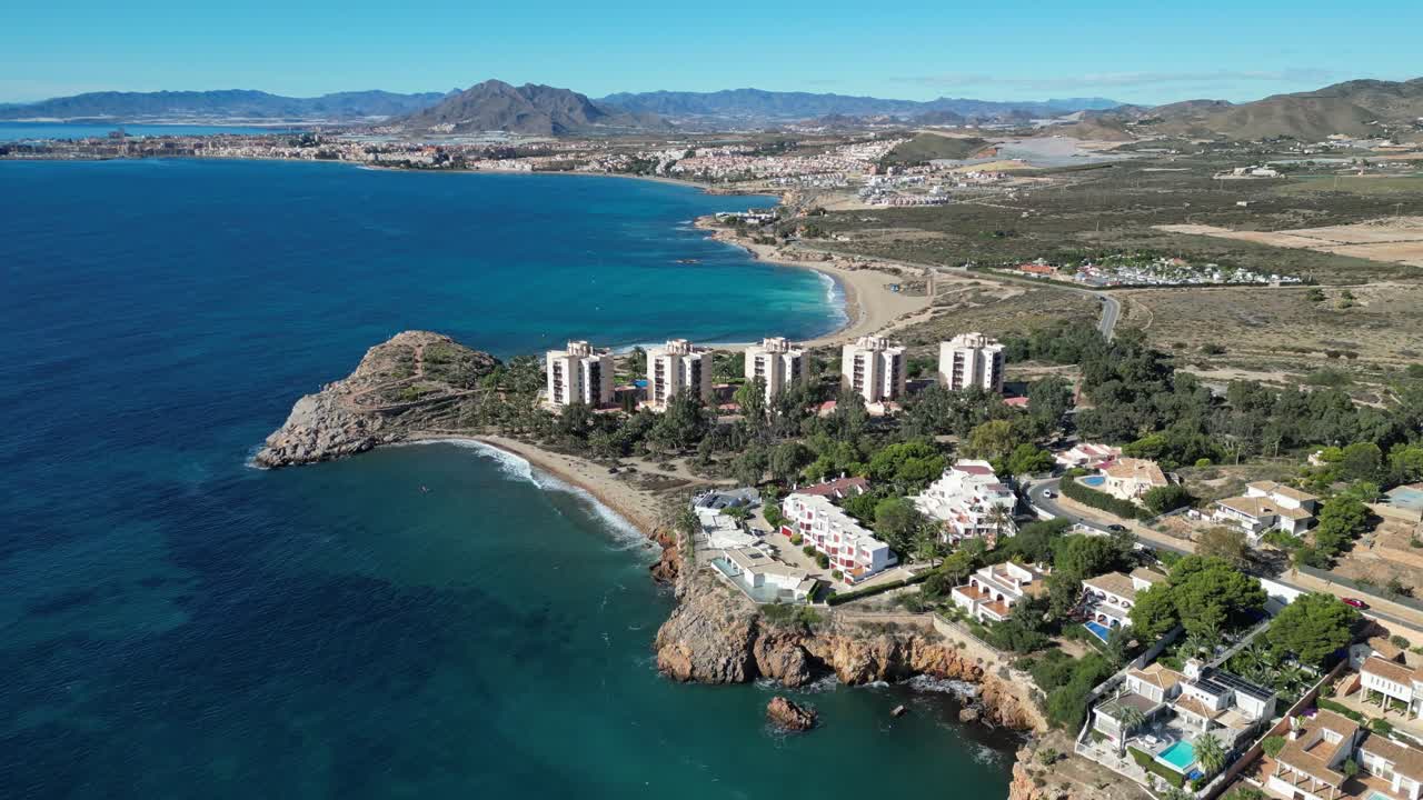 Strandhoteller og naturskøn kyst i Isla Plana, Costa Calida, Cartagena, Murcia, Spanien - Luftoptagelse 4k