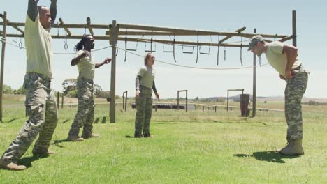 Fit-diverse-group-of-soldiers-doing-press-ups-after-jumping-jacks-on-obstacle-course-in-the-sun